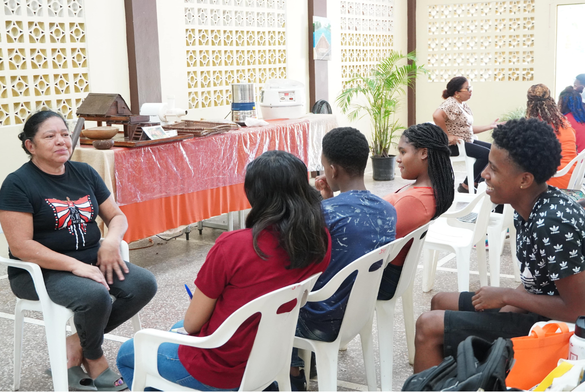 Participants of Cari-Bois' inaugural Youth Environmental Journalism Project practice their interview skills with Lopinot residents during a field trip to community in August 2023.