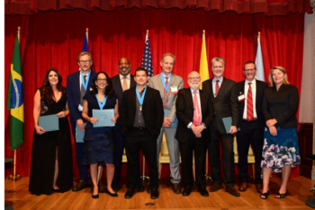 Ten people in formal attire pose for the camera