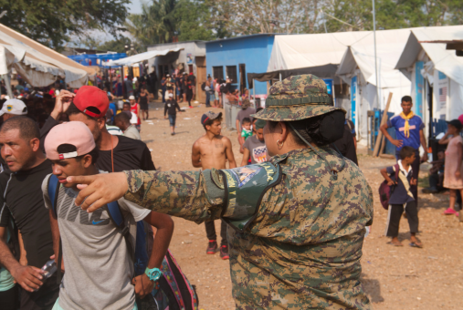 Soldier directing people in a field with