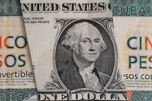 Dollar bill over Cuban pesos