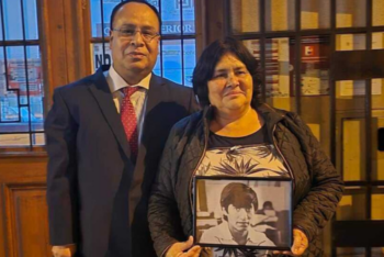 Man and woman take photo. Woman holds photo of another man at typewriter.