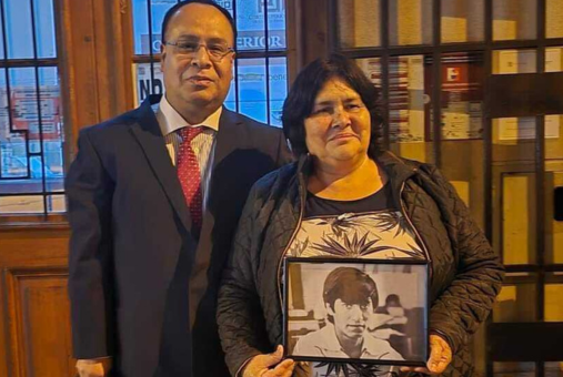 Man and woman take photo. Woman holds photo of another man at typewriter.