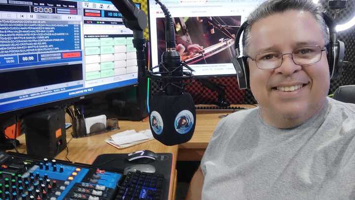 Man in a radio studio; this is Dirley Oliveira, known as Sorriso, who hosts a program on Rádio Avalanche FM in Sena Madureira, Acre, Brazil.