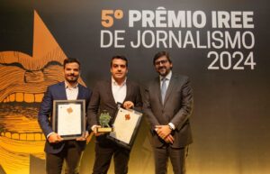 Three men on stage and two accepting awards