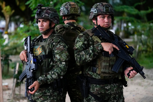 Three soldiers standing back to back with guns drawn