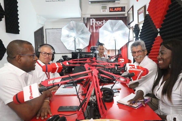 A group of journalists from Colombian media group Proclama del Pacífico engaging in a discussion inside a radio studio.