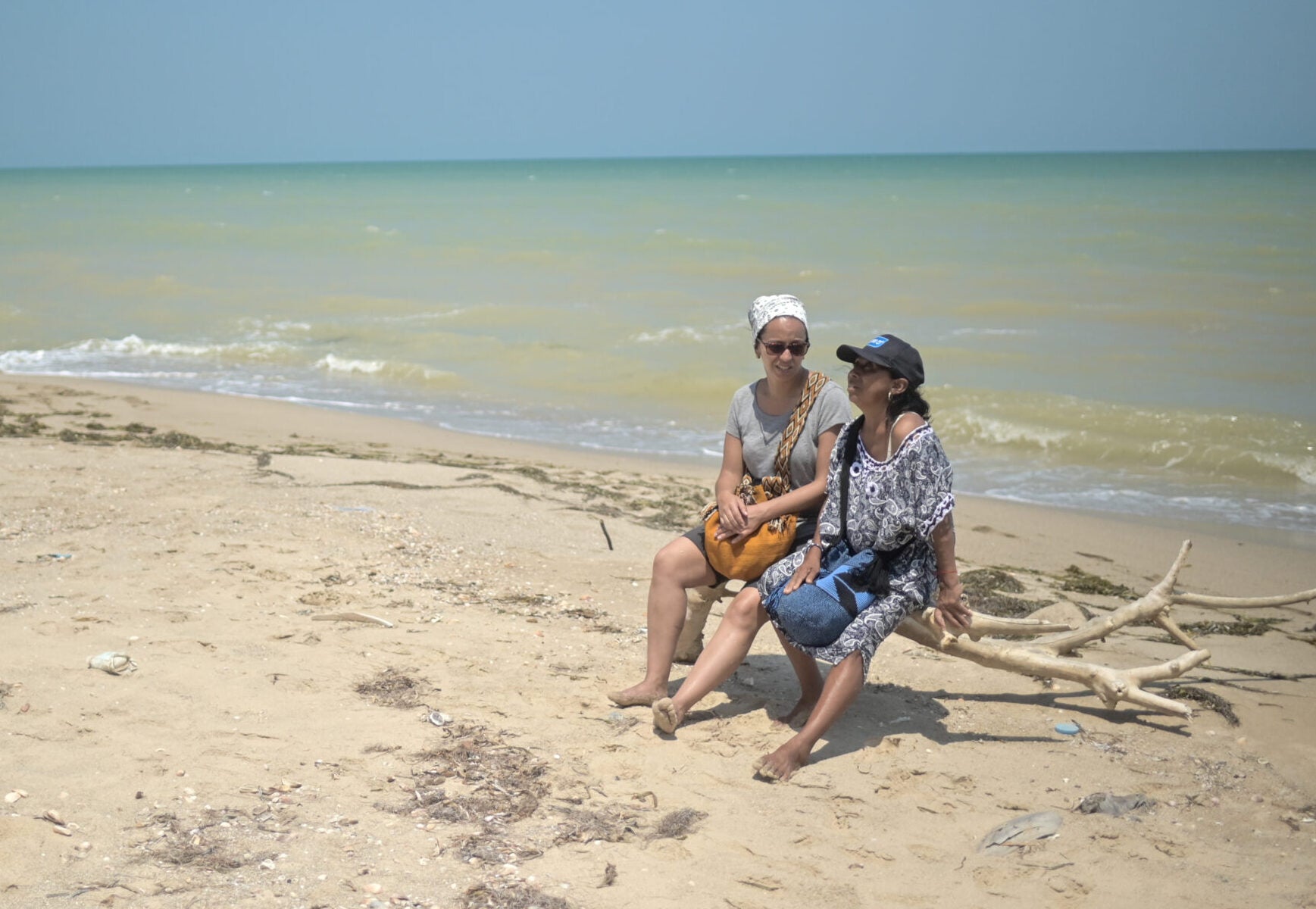 Journalist Laila Shihab interviews environmental defender Clarena Fonseca in a beach in Colombia.