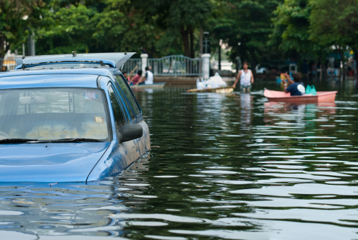 People navigating flooded streets in canoes