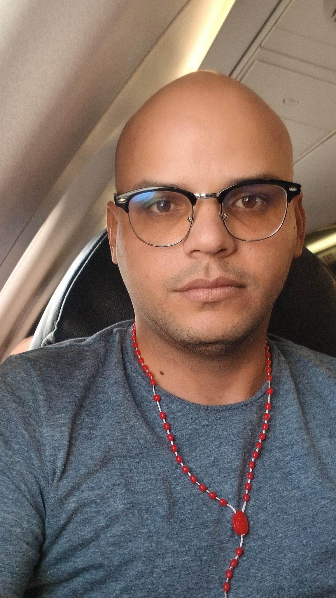 Cuban journalist José Luis Tan seated on a plane seat.