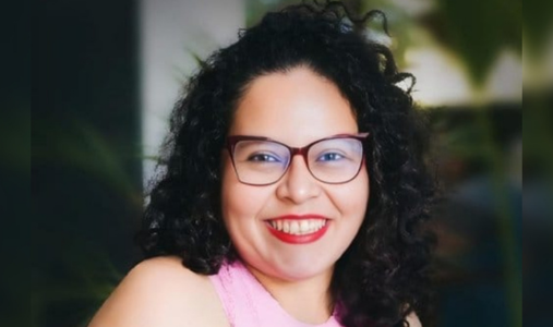 Woman in pink shirt and wearing glasses