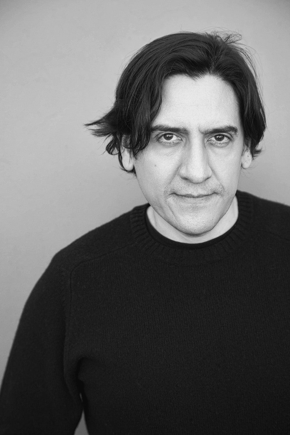 Mexican filmmaker J. Xavier Velasco poses in a black and white portrait.