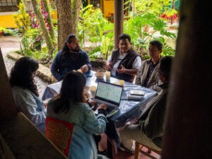 Five people talking to each other around a table