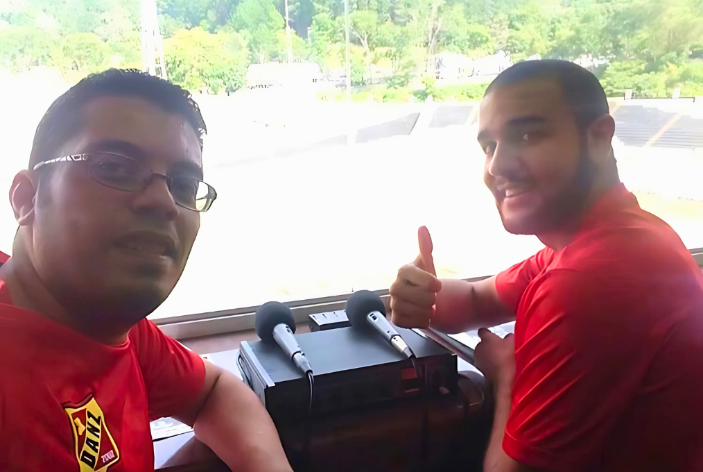 Venezuelan Journalist Diobert Tocuyo (left) poses for a selfie next to a colleague during the coverage of a sports event.