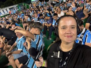 Person in headphones in front of crowd at soccer game