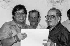 Three men looking at a document smiling.
