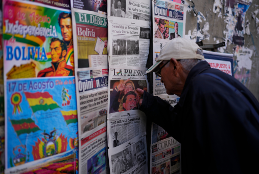 Man looks at newspaper covers