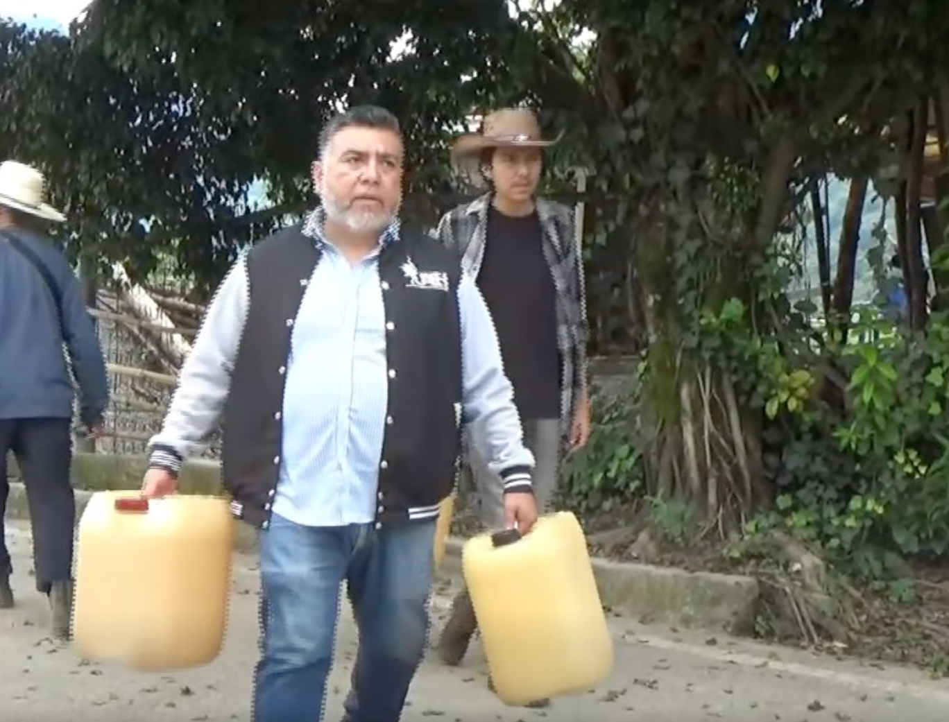 Journalist René Martínez, director of university radio station Radio UAEH San Bartolo, carries cans of diesel during a floods emergency in Hidalgo, México.