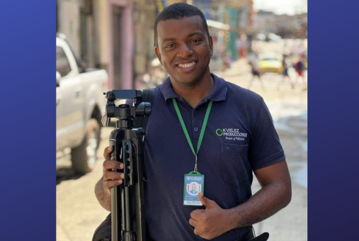 Man giving thumbs up with tripod in hand