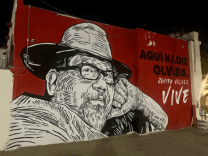 Mural painted in black, white and red of a man with glasses and a hat