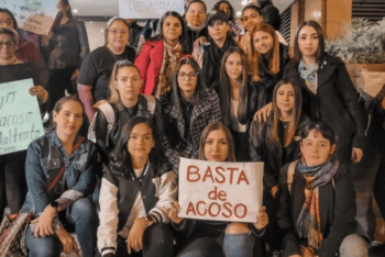 A group of youn women with sign in Spanish "Stop the harassment"