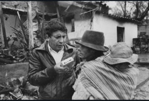 Black and white photo of a young man doing an interview to a woman. 