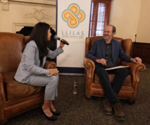 A man and woman sit opposite each other in chairs talking