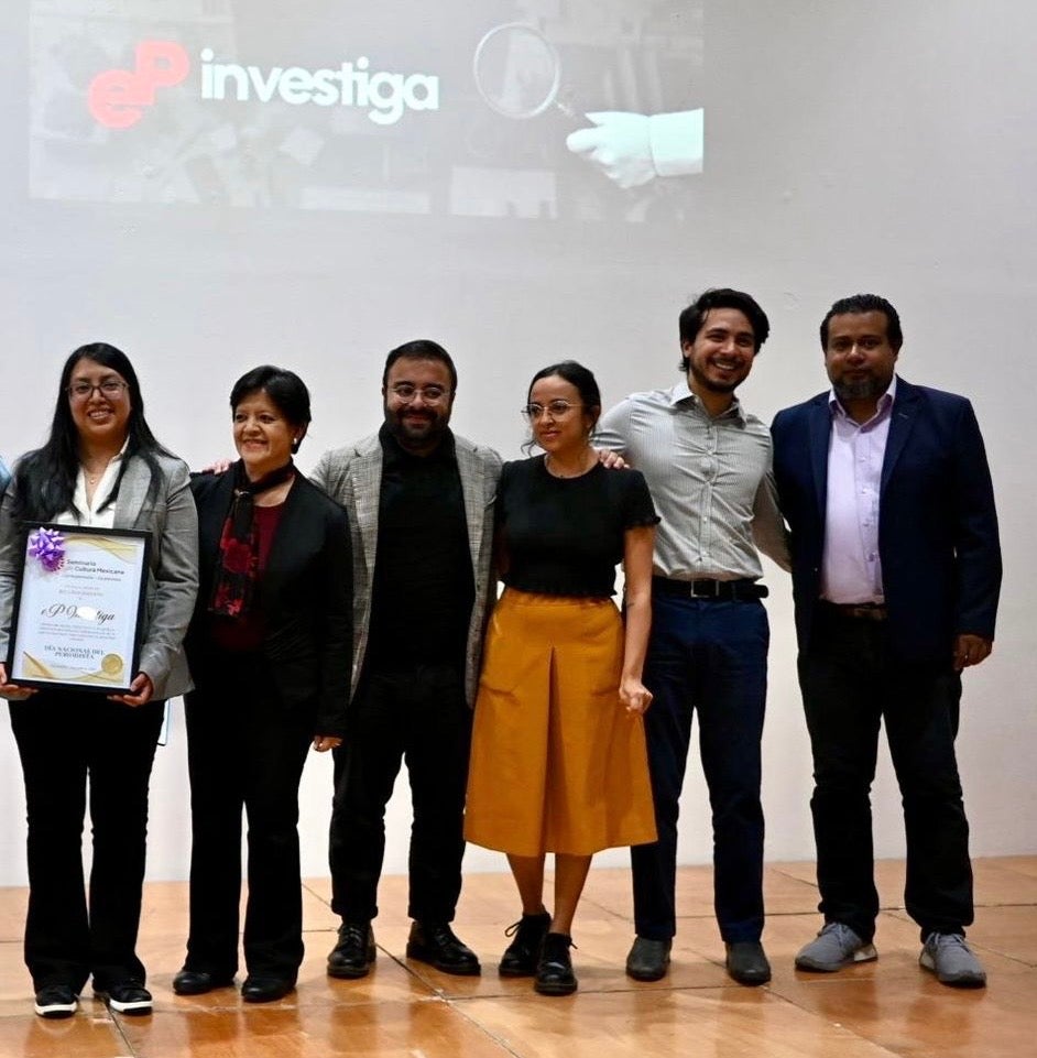 A group of people standing on a stage receiving an award